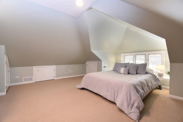 bedroom featuring lofted ceiling, visible vents, and light carpet