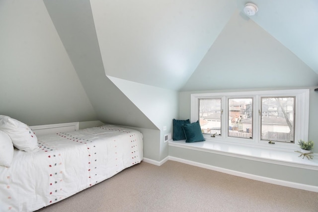 unfurnished bedroom with vaulted ceiling, carpet flooring, and baseboards