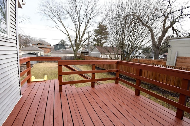 wooden deck with a residential view, a fenced backyard, and a yard