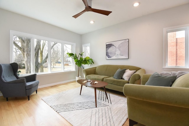 living area featuring baseboards, ceiling fan, light wood-style flooring, and recessed lighting