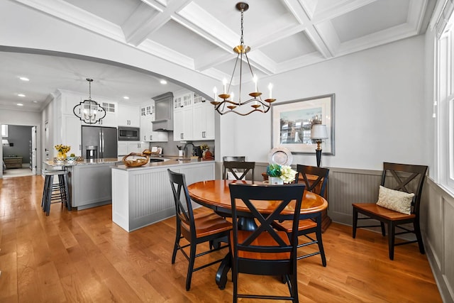 dining space featuring coffered ceiling, beam ceiling, light hardwood / wood-style flooring, and a notable chandelier