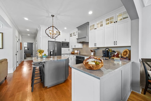 kitchen featuring white cabinetry, decorative light fixtures, sink, and black appliances