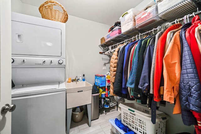 clothes washing area featuring stacked washing maching and dryer