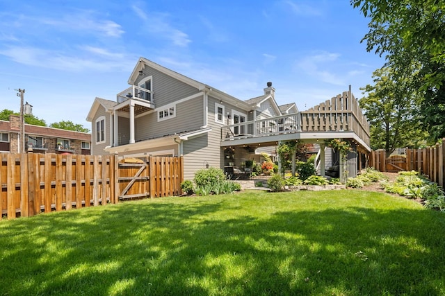 rear view of property with a yard and a balcony