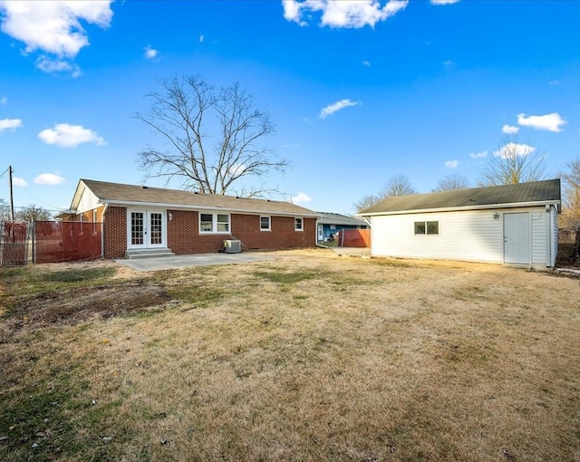 rear view of house with french doors, a patio, a lawn, and cooling unit