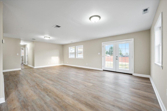 empty room with wood-type flooring and french doors