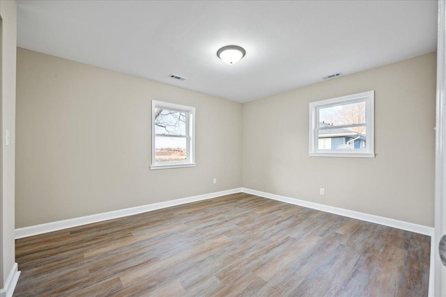 unfurnished room featuring a wealth of natural light and light wood-type flooring