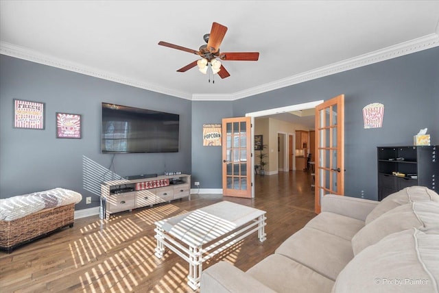 living area with french doors, ornamental molding, a ceiling fan, wood finished floors, and baseboards