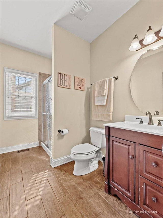 bathroom featuring toilet, a stall shower, visible vents, and vanity