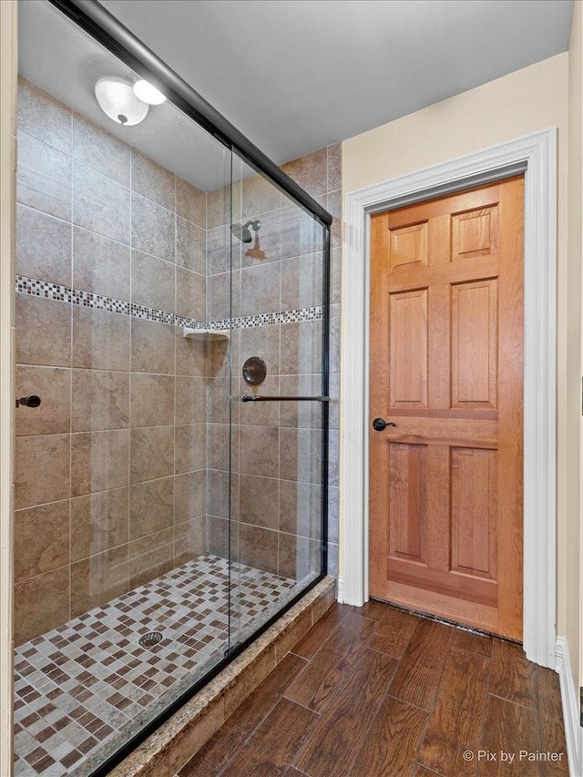 bathroom with a stall shower and wood finished floors