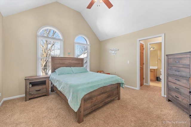 bedroom with light carpet, vaulted ceiling, ensuite bath, and baseboards