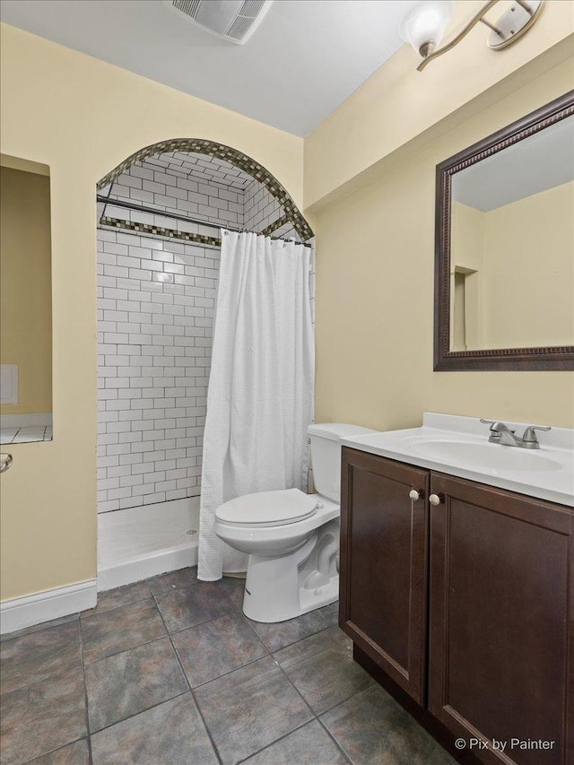 bathroom featuring visible vents, vanity, toilet, and tiled shower