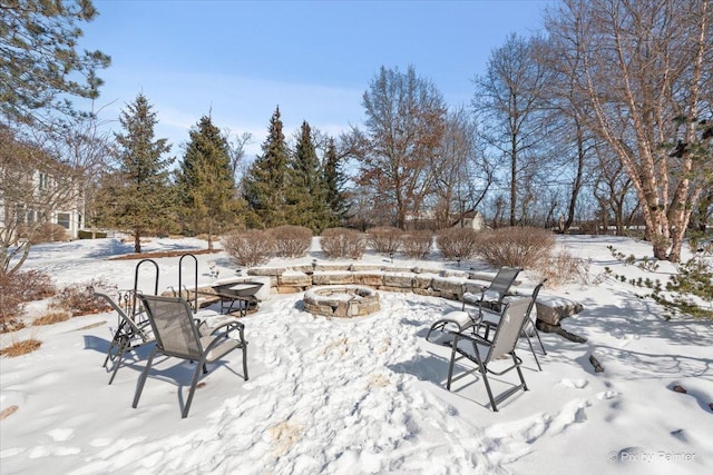 snow covered patio featuring an outdoor fire pit