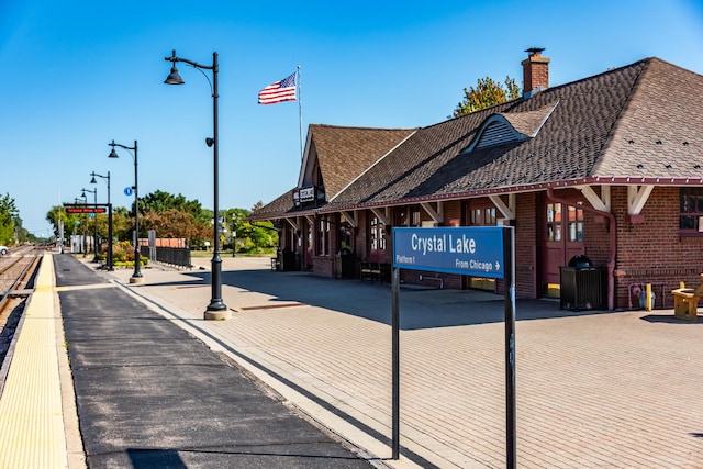 view of road with sidewalks, street lighting, and curbs