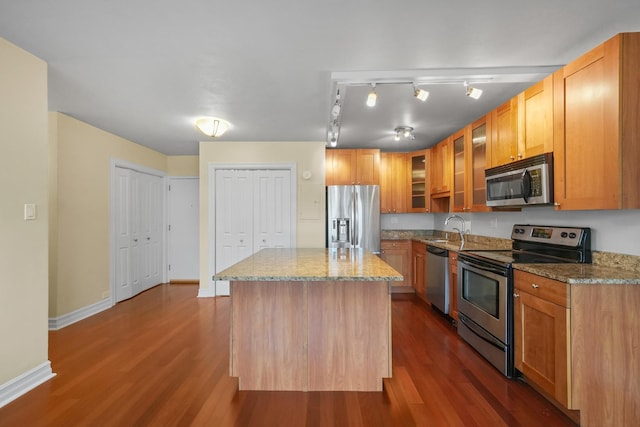 kitchen with stainless steel appliances, dark hardwood / wood-style floors, a center island, and sink