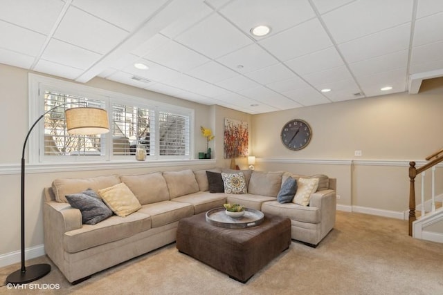 carpeted living room with a drop ceiling