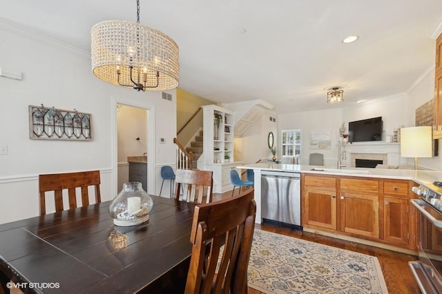 dining space with crown molding, sink, a chandelier, and dark hardwood / wood-style flooring