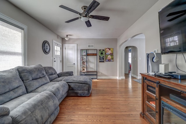 living room with ceiling fan, wood-type flooring, and a wealth of natural light