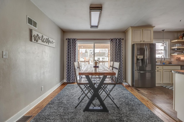 dining area featuring plenty of natural light, sink, and hardwood / wood-style floors