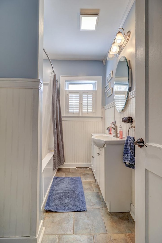 bathroom featuring vanity and shower / bathtub combination with curtain