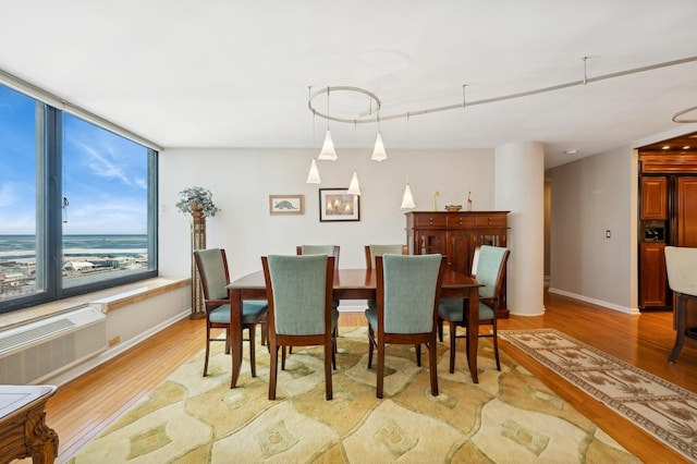 dining room featuring light hardwood / wood-style floors and an AC wall unit