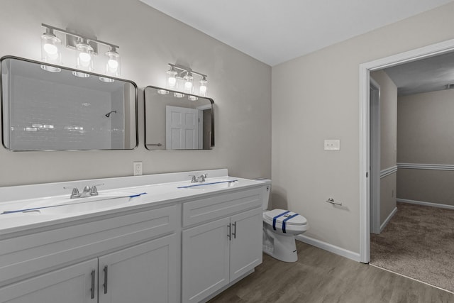 bathroom featuring vanity, a shower, hardwood / wood-style floors, and toilet