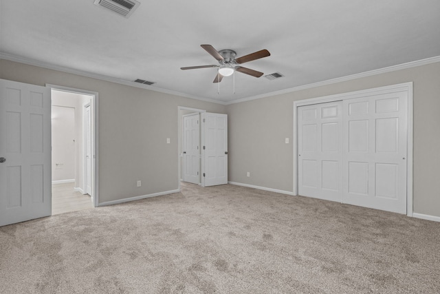 unfurnished bedroom with a closet, ornamental molding, ensuite bath, and light carpet