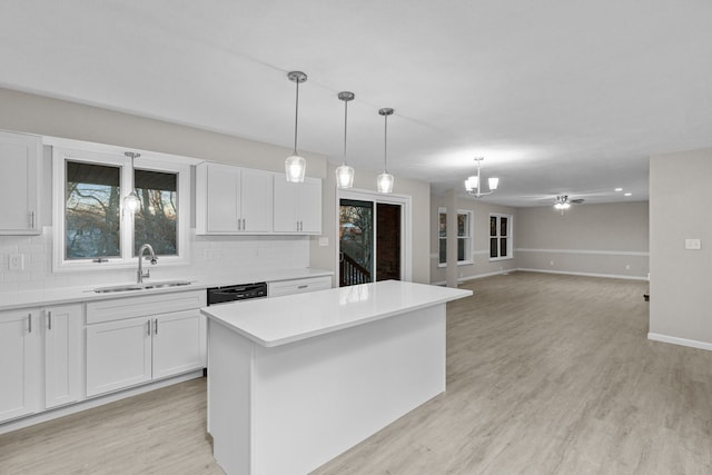 kitchen with white cabinetry, sink, decorative light fixtures, and a center island