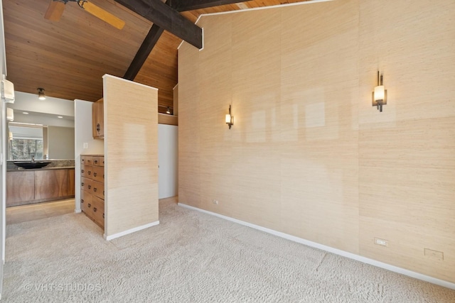 interior space with beam ceiling, high vaulted ceiling, wooden ceiling, baseboards, and light colored carpet