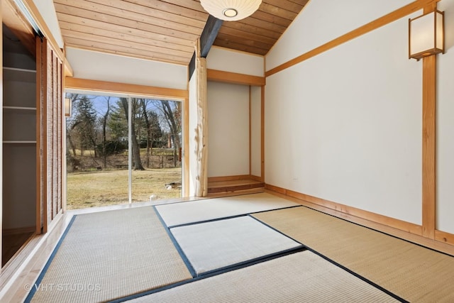 empty room featuring lofted ceiling, baseboards, and wooden ceiling