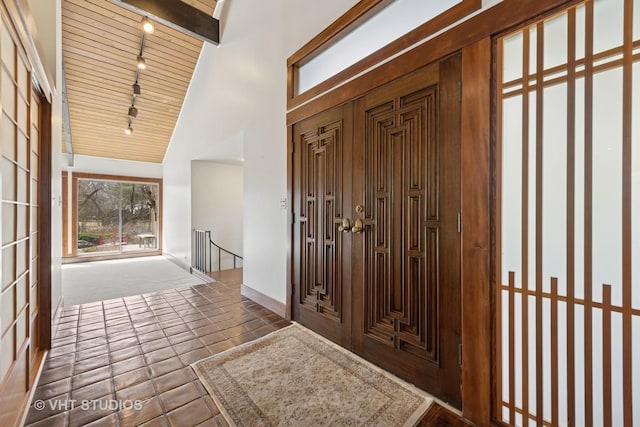 foyer entrance featuring high vaulted ceiling and rail lighting