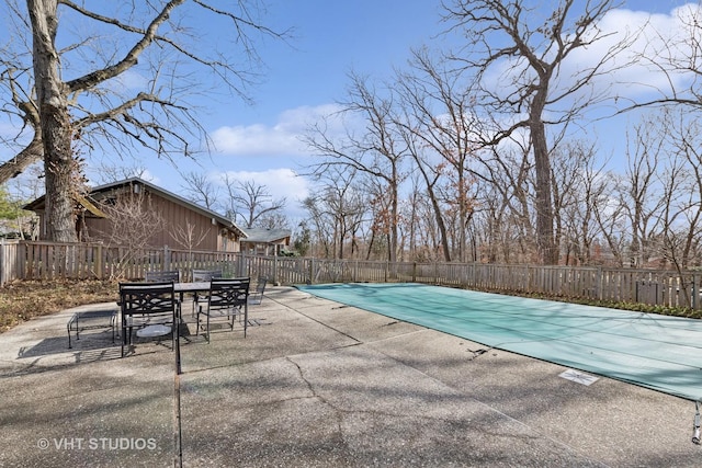 view of pool with a patio, outdoor dining area, fence, and a fenced in pool