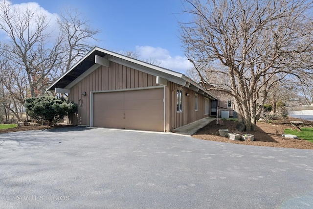 view of side of home with aphalt driveway and a garage