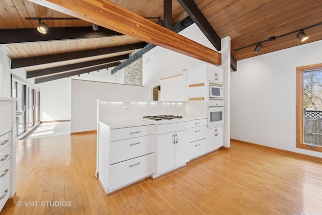 kitchen featuring vaulted ceiling with beams, light countertops, light wood-style floors, white cabinets, and white appliances