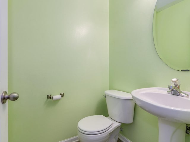 bathroom featuring baseboards and toilet