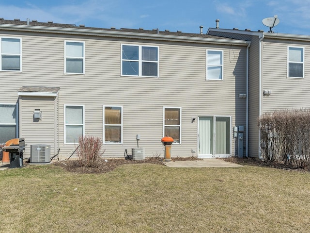 back of property featuring cooling unit and a lawn