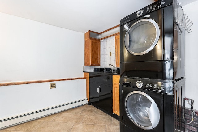 washroom with sink, cabinets, light tile patterned floors, baseboard heating, and stacked washer / dryer