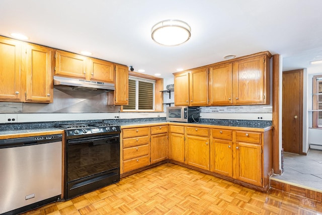 kitchen with a baseboard radiator, light parquet flooring, and appliances with stainless steel finishes