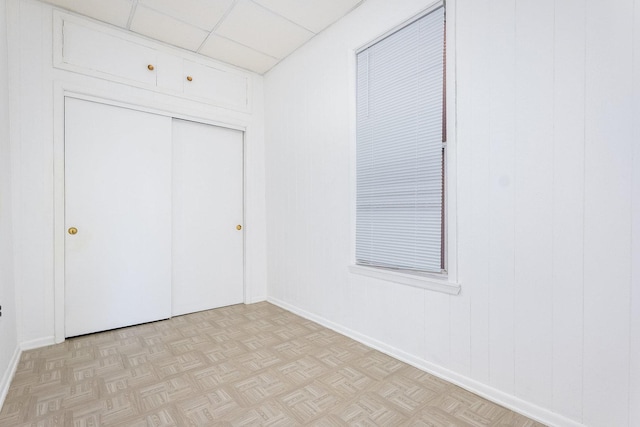 spare room featuring a paneled ceiling and light parquet floors