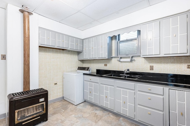 kitchen with heating unit, sink, washer / dryer, and gray cabinetry