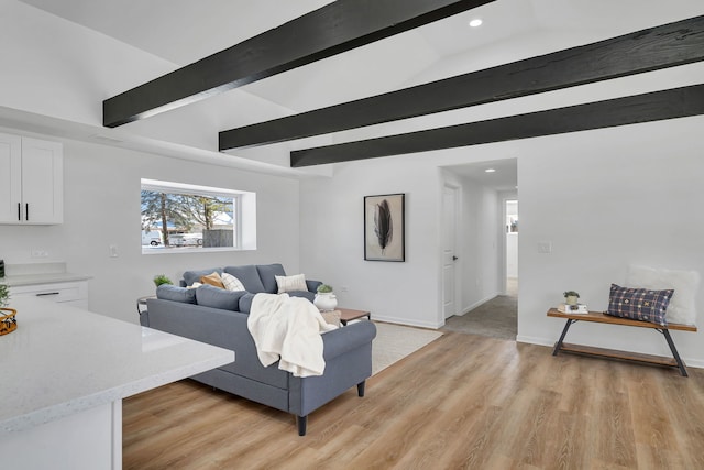 living room featuring light hardwood / wood-style flooring and vaulted ceiling with beams