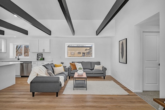 living room with sink, beam ceiling, and light hardwood / wood-style floors