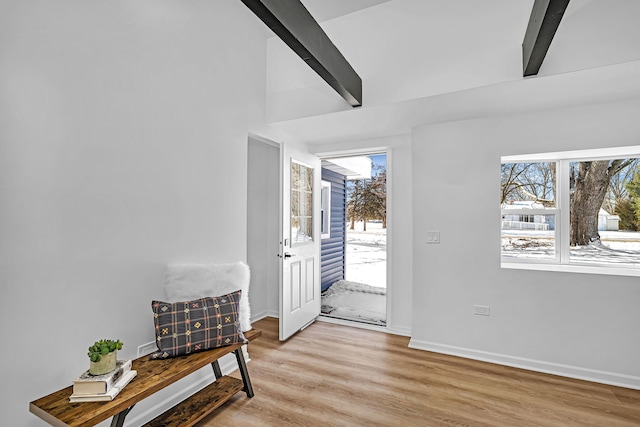 entryway featuring beamed ceiling and light wood-type flooring