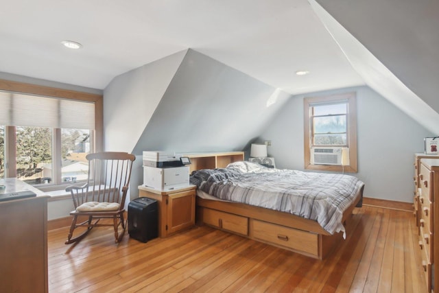 bedroom with cooling unit, baseboards, vaulted ceiling, and light wood finished floors