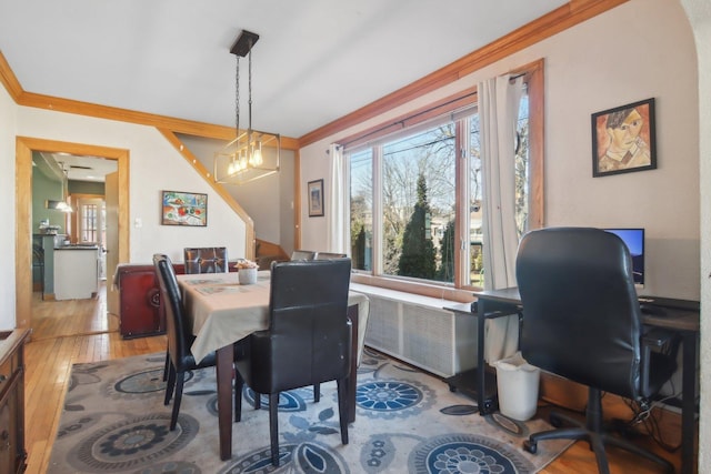 dining room featuring radiator heating unit, crown molding, and hardwood / wood-style floors