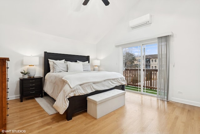 bedroom with access to exterior, light wood-style flooring, vaulted ceiling, and a wall mounted air conditioner