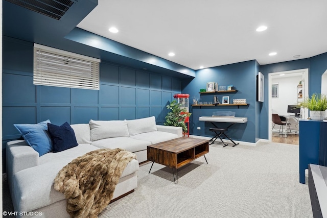 carpeted living room with baseboards, visible vents, a decorative wall, and recessed lighting