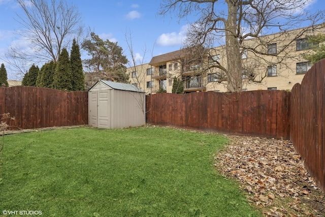 view of yard featuring an outbuilding, a fenced backyard, and a storage unit