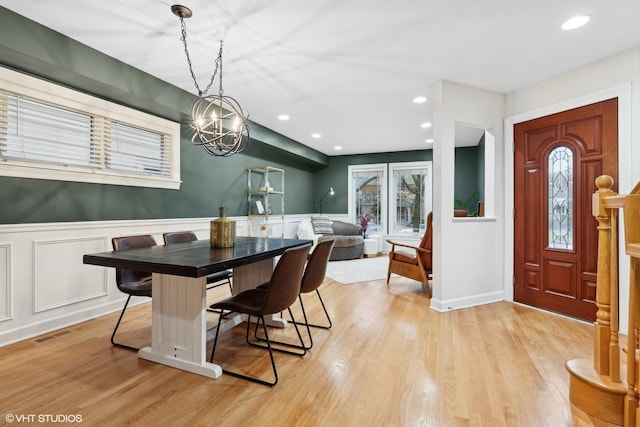 dining area with light wood-style floors, recessed lighting, a wainscoted wall, and visible vents