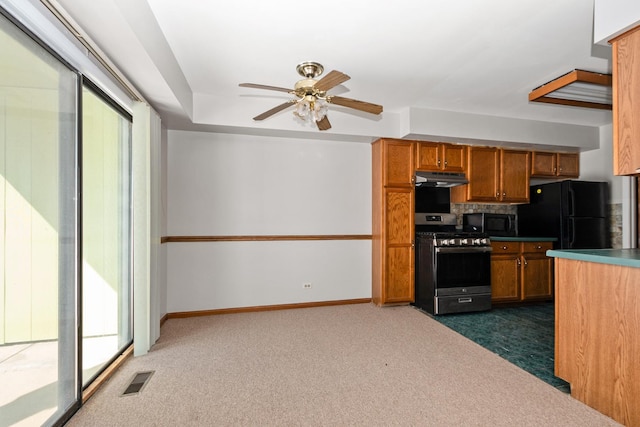 kitchen featuring dark colored carpet, ceiling fan, and black appliances